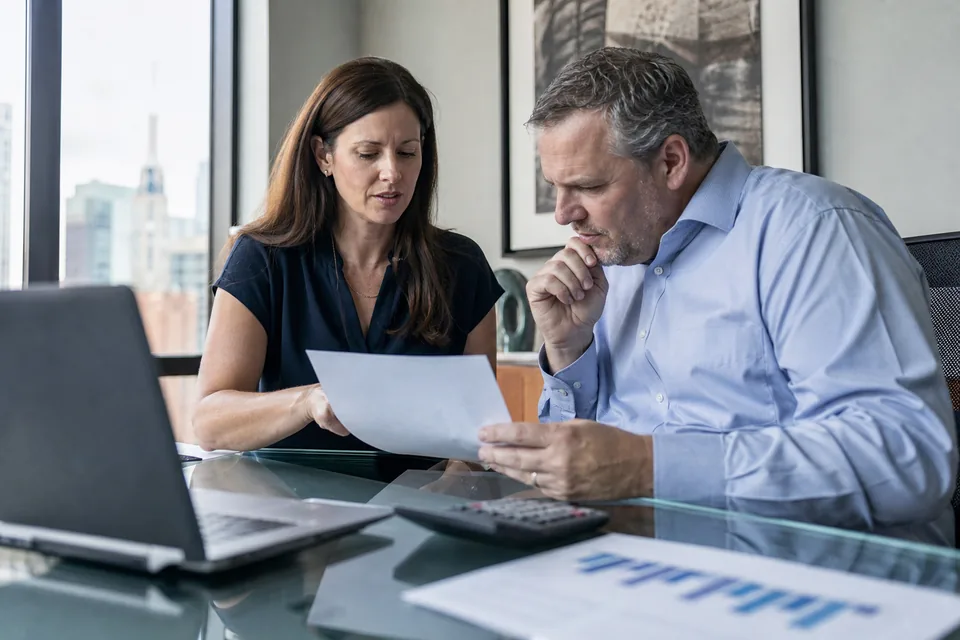 Marketing director and finance manager going over a software quote at a conference table