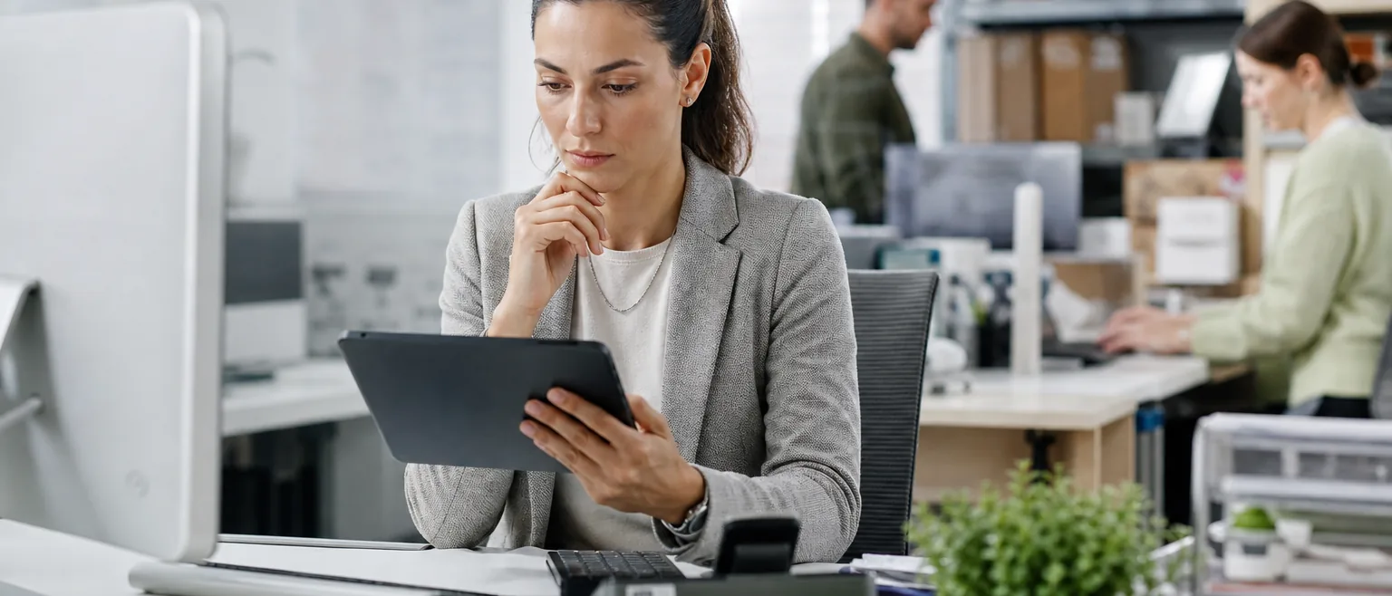 Operations lead reading customer reviews on a tablet in a retail back office